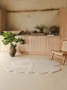 Quatro shearling rug in Moonlight on a stone floor