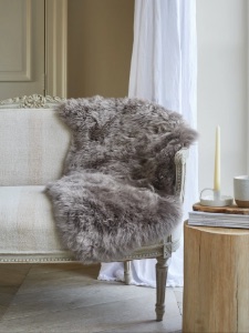 Sheepskin rug in Vole draped over a chair